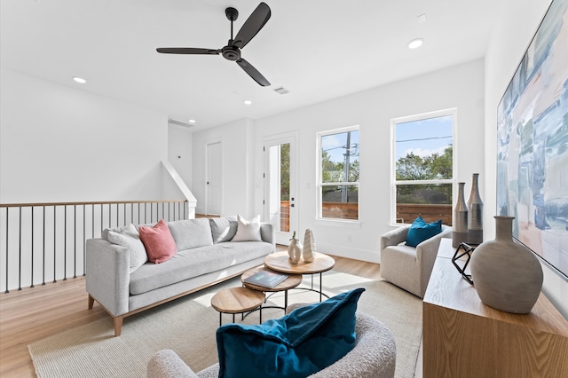 living room with light hardwood / wood-style flooring and ceiling fan