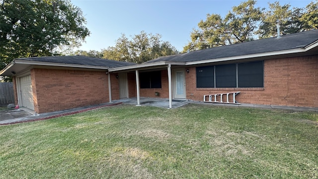 rear view of house featuring a patio area, a lawn, and a garage