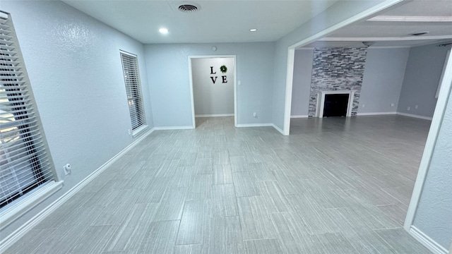 unfurnished living room featuring a large fireplace and light hardwood / wood-style floors