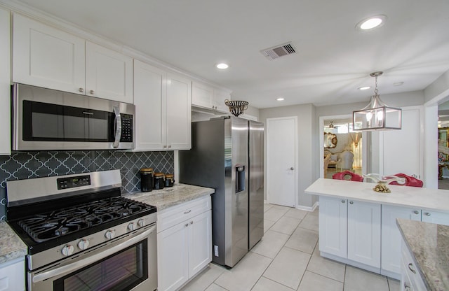 kitchen featuring a notable chandelier, white cabinetry, stainless steel appliances, and pendant lighting