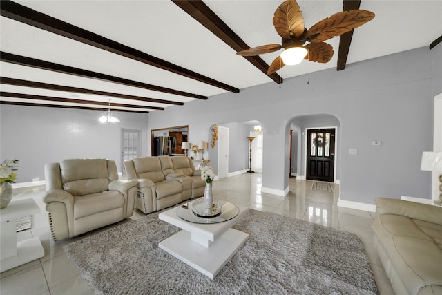 tiled living room featuring a notable chandelier and beam ceiling