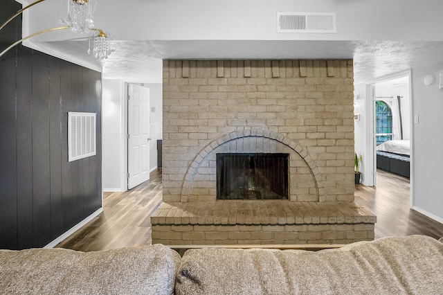 living room featuring wooden walls, wood-type flooring, and a fireplace