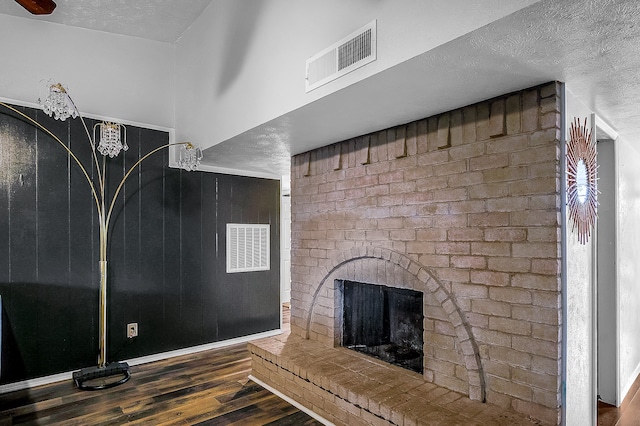 unfurnished living room with a textured ceiling, a fireplace, and dark hardwood / wood-style floors