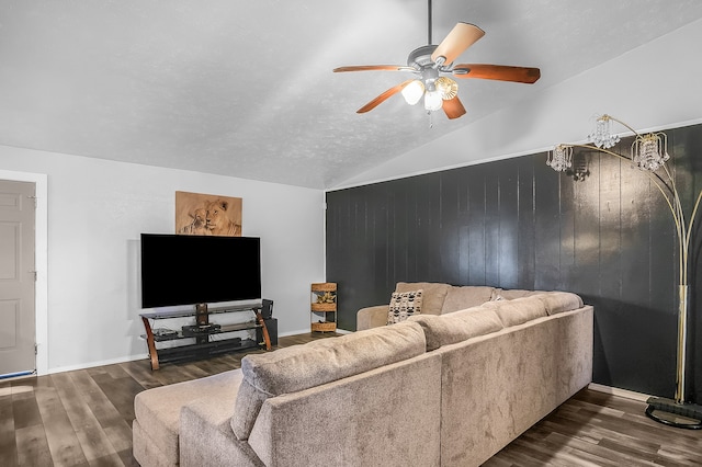 living room with lofted ceiling, ceiling fan, wooden walls, and dark hardwood / wood-style flooring