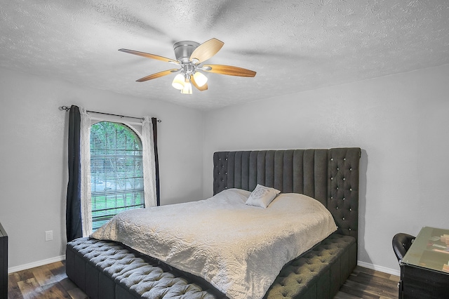 bedroom featuring a textured ceiling, dark hardwood / wood-style floors, and ceiling fan