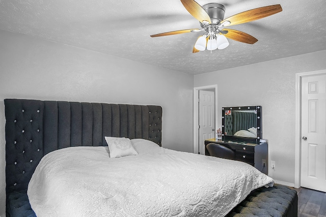 bedroom with ceiling fan, a textured ceiling, and dark hardwood / wood-style flooring