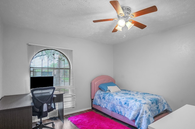 bedroom with ceiling fan, a textured ceiling, and hardwood / wood-style floors