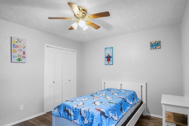 bedroom featuring a closet, a textured ceiling, dark wood-type flooring, and ceiling fan