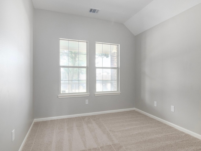 carpeted empty room featuring vaulted ceiling