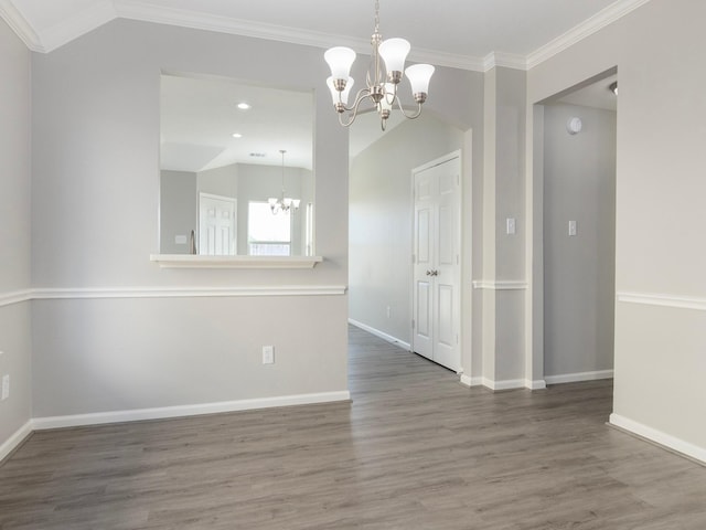 unfurnished dining area featuring wood-type flooring, ornamental molding, and a notable chandelier