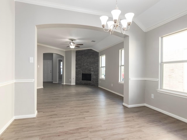 unfurnished living room featuring a wealth of natural light, light hardwood / wood-style floors, ceiling fan with notable chandelier, and ornamental molding