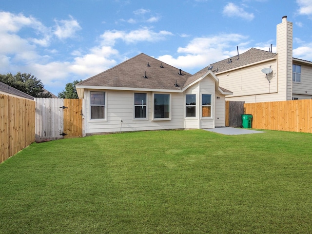 rear view of property with a yard and a patio