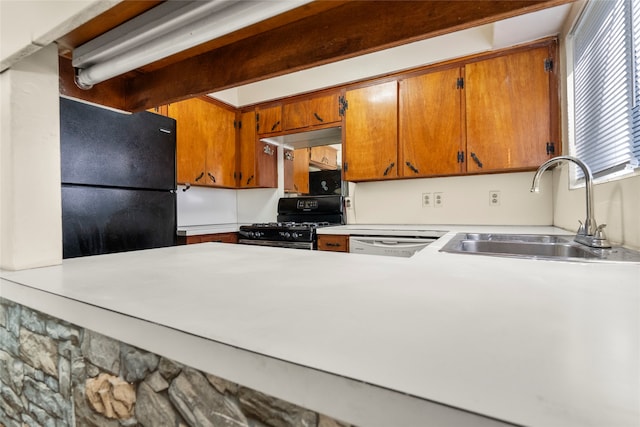 kitchen with beam ceiling, black appliances, and sink