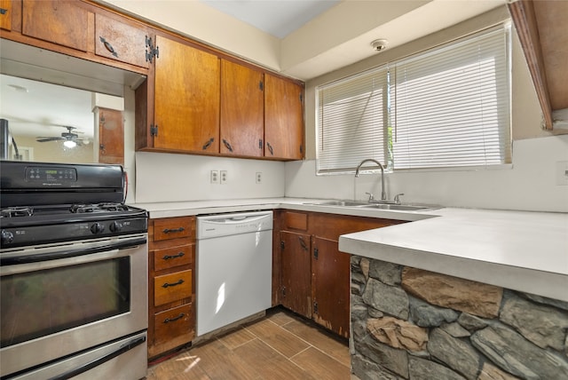 kitchen with gas stove, ceiling fan, hardwood / wood-style flooring, white dishwasher, and sink