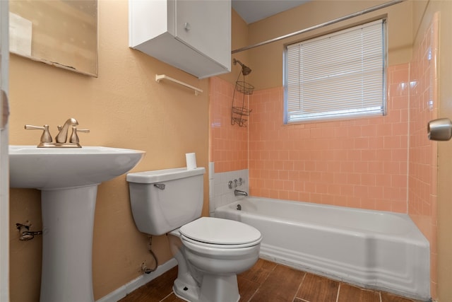 bathroom featuring toilet, tiled shower / bath, and hardwood / wood-style flooring