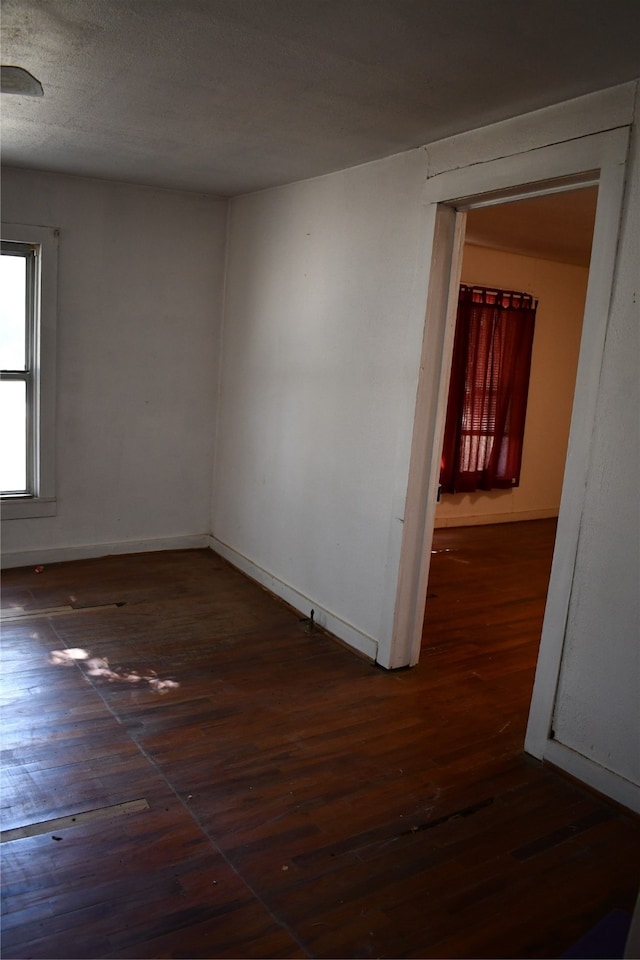 unfurnished room featuring dark hardwood / wood-style floors and a textured ceiling