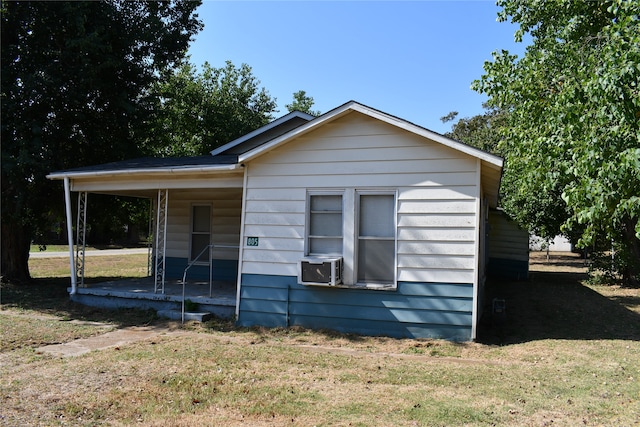 view of side of home with cooling unit and a lawn