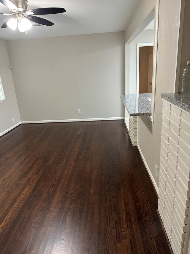 unfurnished living room with ceiling fan and dark hardwood / wood-style flooring