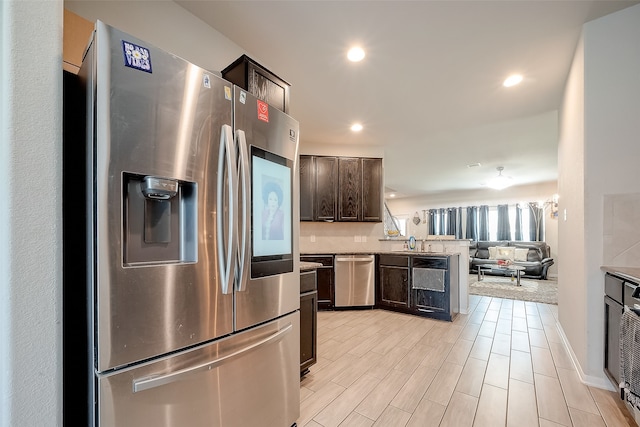 kitchen featuring sink, dark brown cabinets, light hardwood / wood-style floors, and appliances with stainless steel finishes