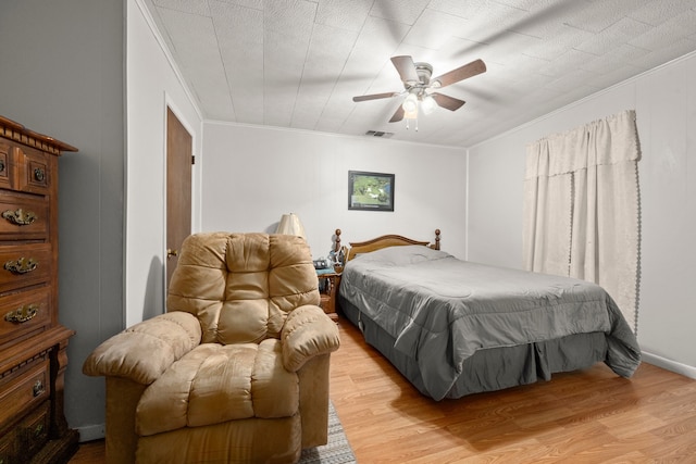 bedroom with ceiling fan, crown molding, and light hardwood / wood-style floors