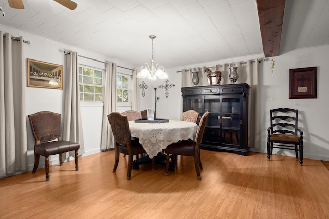 dining area with crown molding, wood-type flooring, and ceiling fan with notable chandelier