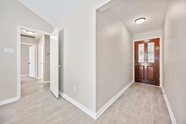 foyer with light hardwood / wood-style floors and vaulted ceiling