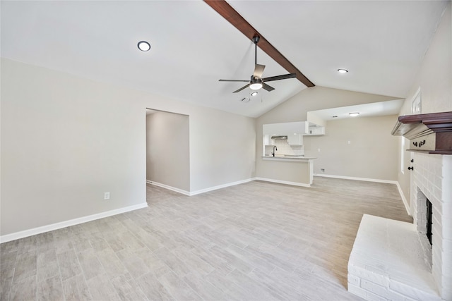 unfurnished living room with light hardwood / wood-style flooring, lofted ceiling with beams, ceiling fan, and a brick fireplace