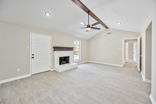 unfurnished living room with a fireplace, lofted ceiling with beams, light wood-type flooring, and ceiling fan