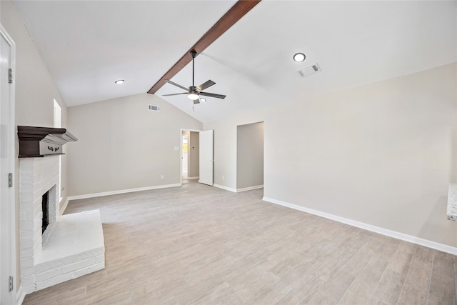 unfurnished living room featuring lofted ceiling with beams, a brick fireplace, light wood-type flooring, and ceiling fan