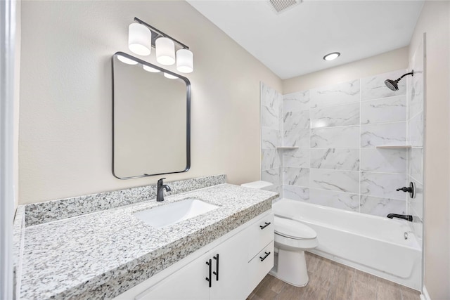 full bathroom featuring vanity, toilet, tiled shower / bath combo, and hardwood / wood-style floors