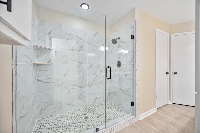 bathroom featuring a shower with door and hardwood / wood-style floors