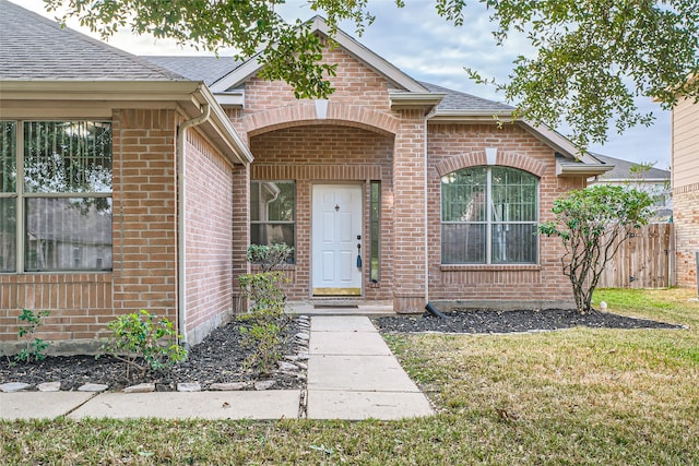 view of exterior entry with a lawn