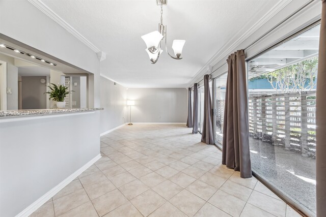 tiled empty room featuring ornamental molding and an inviting chandelier