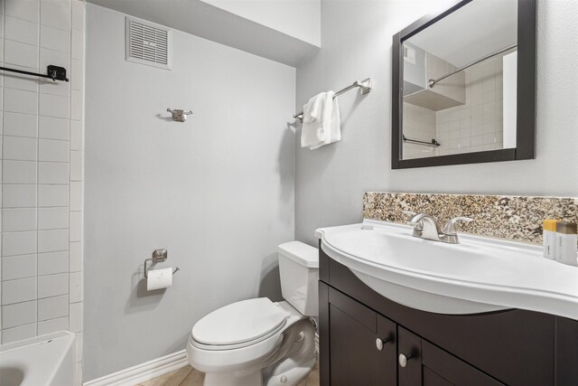 full bathroom featuring vanity, toilet, tile patterned floors, and tiled shower / bath