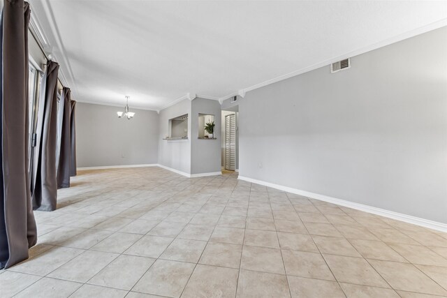 tiled spare room with crown molding and an inviting chandelier