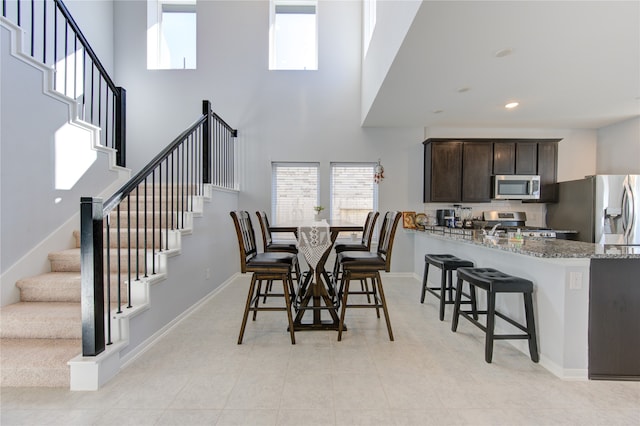 dining area featuring a healthy amount of sunlight and a high ceiling