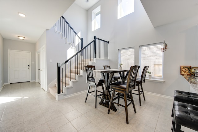 tiled dining room with a towering ceiling