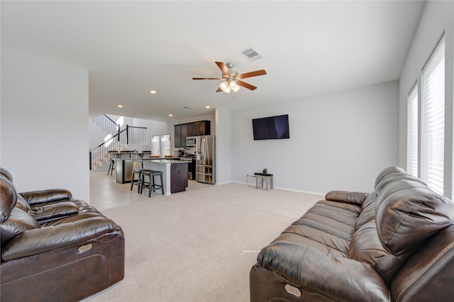 living room with light colored carpet and ceiling fan