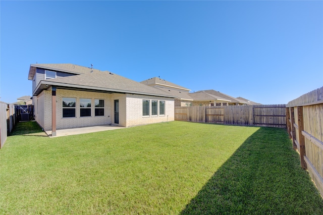 back of house with a yard and a patio