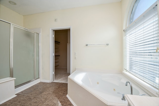 bathroom with tile patterned flooring, a healthy amount of sunlight, and separate shower and tub