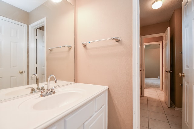 bathroom with vanity, a textured ceiling, and tile patterned flooring