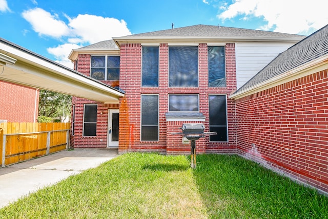 back of property featuring a patio area and a lawn