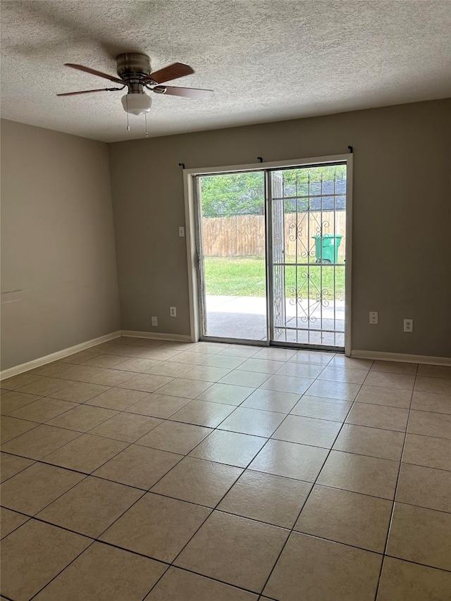 tiled empty room featuring ceiling fan and a textured ceiling