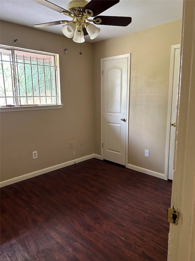 spare room with dark wood-type flooring and ceiling fan