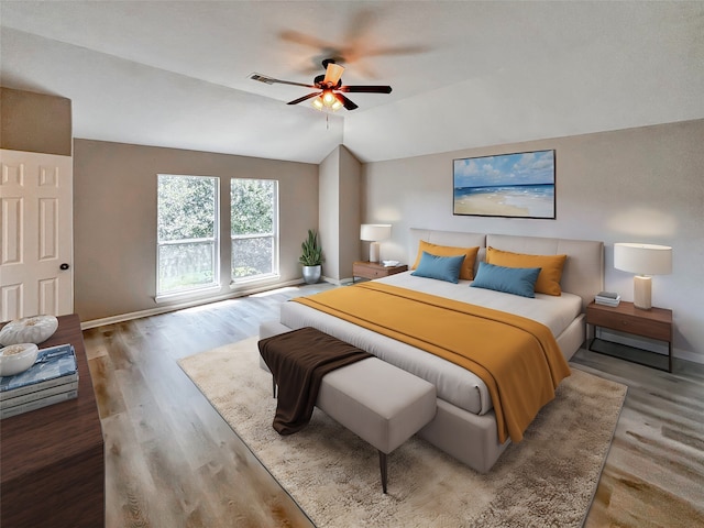 bedroom featuring ceiling fan, hardwood / wood-style flooring, and vaulted ceiling