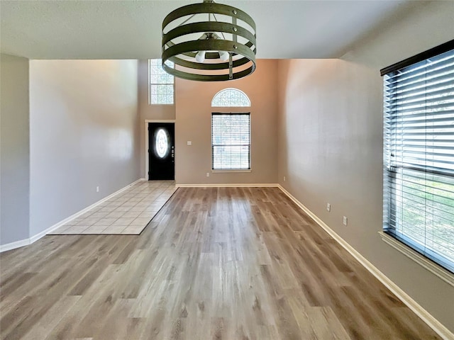 foyer with a notable chandelier, a high ceiling, and light wood-type flooring