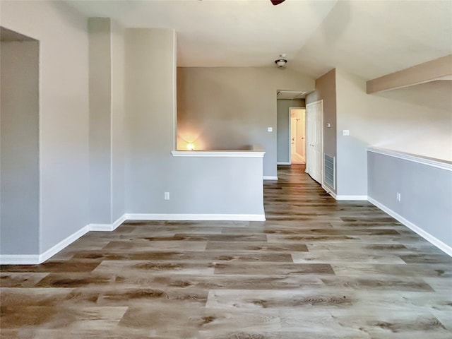 empty room with vaulted ceiling, hardwood / wood-style flooring, and ceiling fan