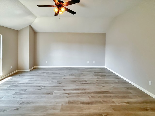 unfurnished room featuring light hardwood / wood-style floors, vaulted ceiling, and ceiling fan