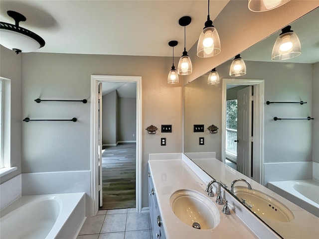 bathroom featuring vanity, tile patterned floors, and a bath