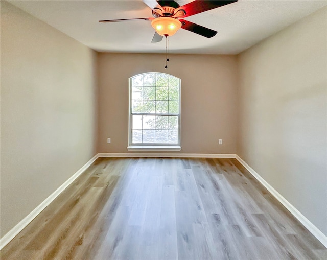 unfurnished room with light wood-type flooring and ceiling fan